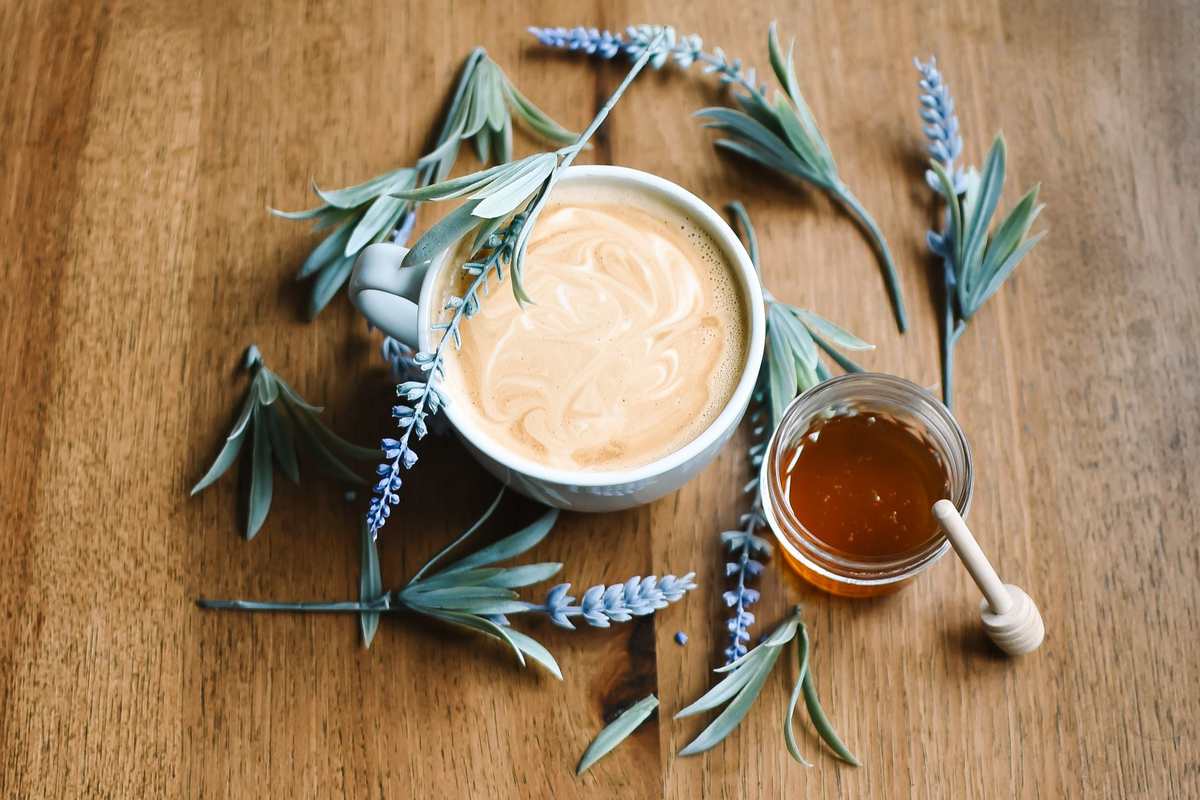 Tasse de café au lait avec miel et lavande sur bois